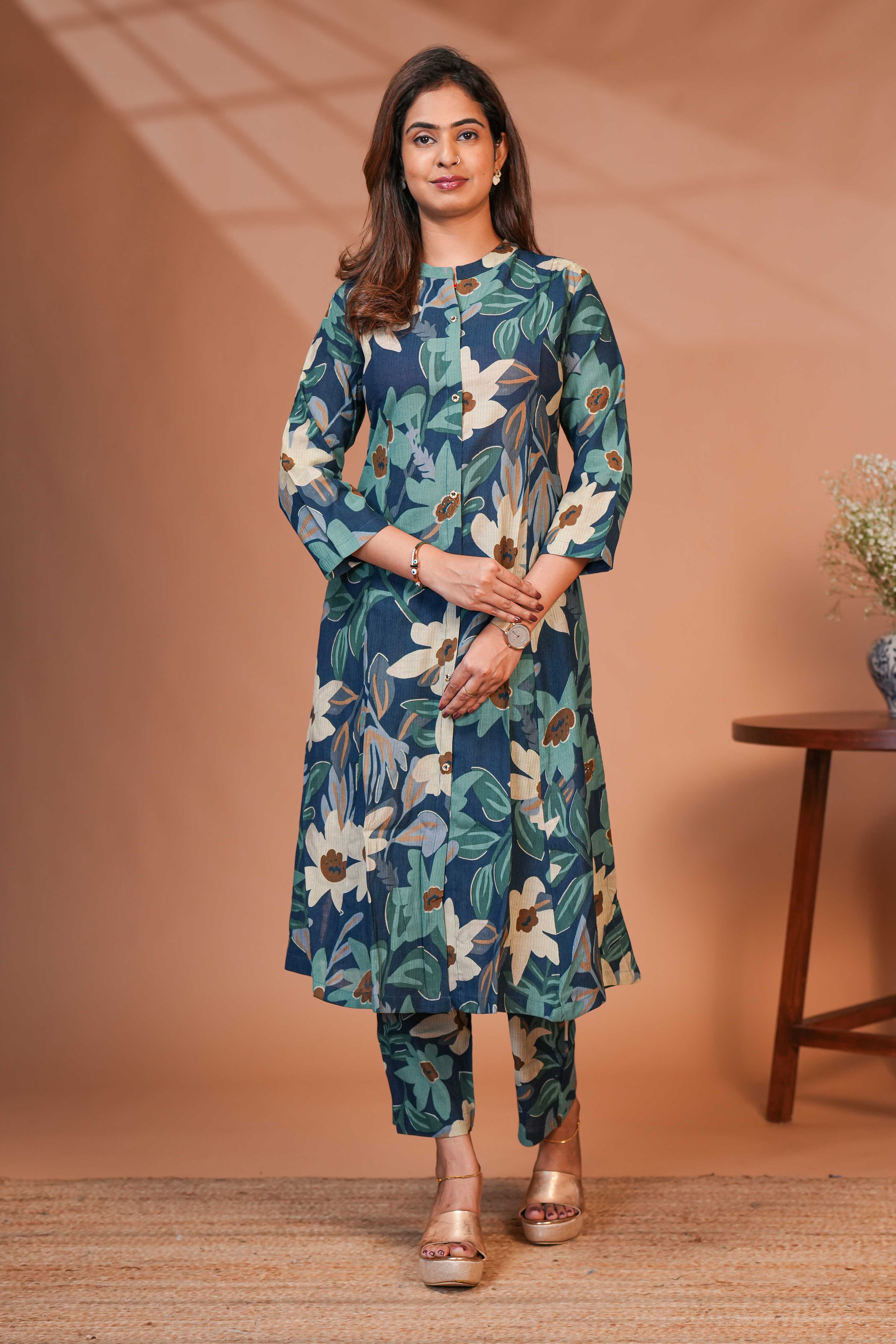A Calf-Length Tunic Featuring a Structured Mandari A Rich Deep Teal-Blue Base,